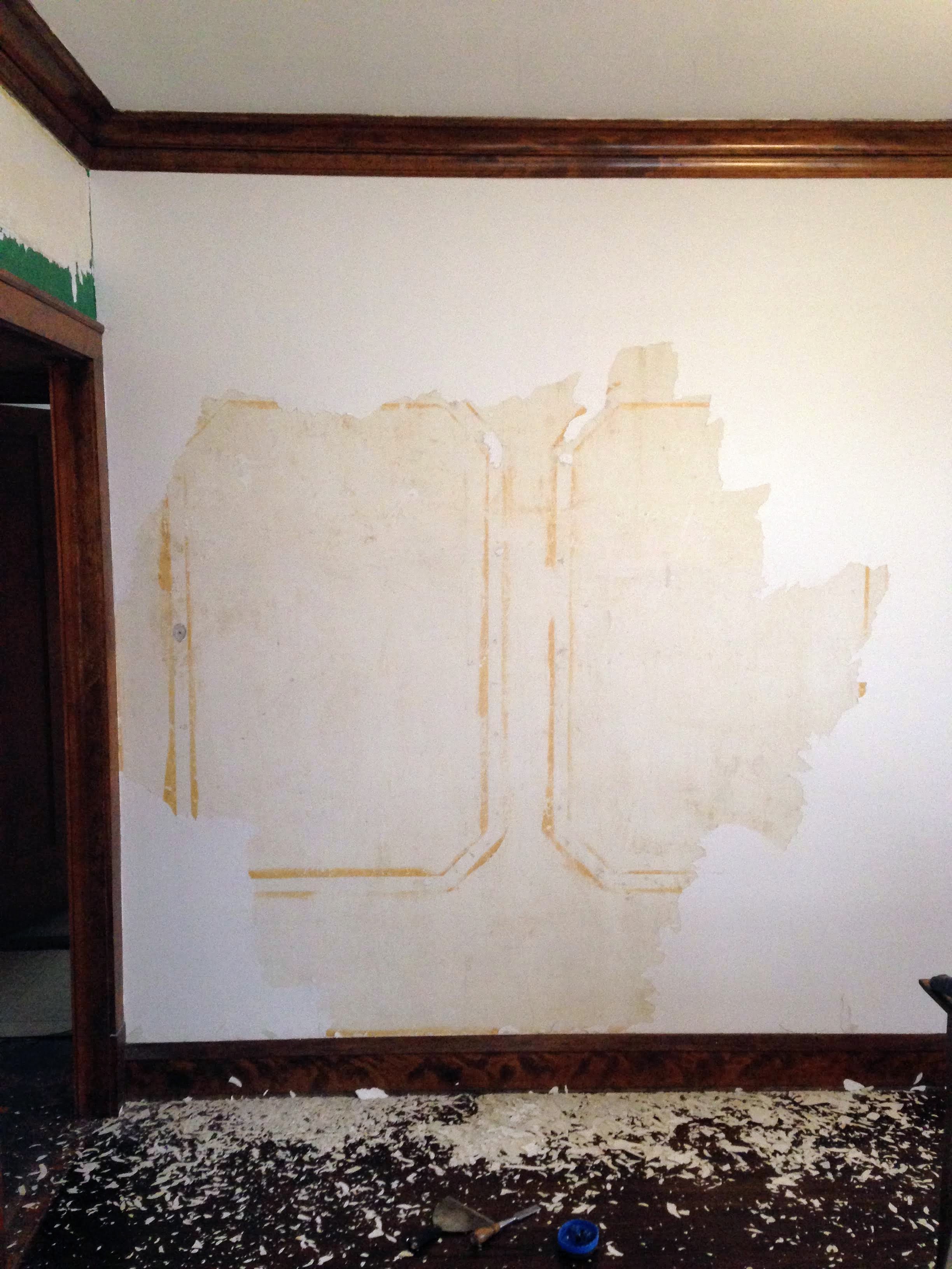 A second wall with paint chipped off of it revealing more panels. 